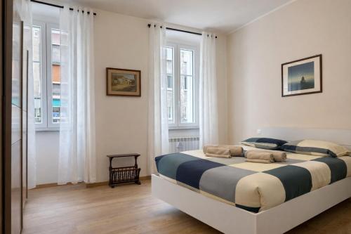 a bedroom with a large bed in a room with windows at Trilocale spazioso a 6 minuti dal centro in Trieste