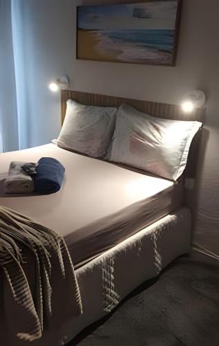 a bed with white sheets and pillows in a bedroom at Lotf Privativo in Volta Redonda