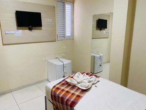 a room with a bed with a tv and a mirror at Gaivota Hotel in Eldorado dos Carajás