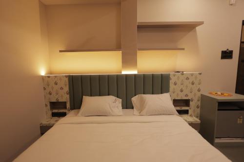 a bed with two white pillows in a room at Hotel Best Inn in Valsād