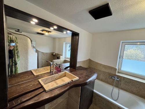 a bathroom with a sink and a mirror and a tub at Tirol Stay in Ebbs