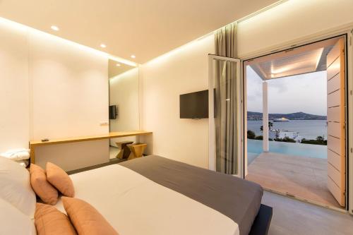 a bedroom with a bed and a view of the ocean at Paros Agnanti Resort & Spa in Parikia