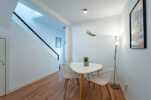 a white dining room with a table and chairs at Oporto Maria Pia With Terrace Suite 4 in Porto