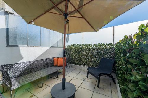a patio with a bench and an umbrella and a chair at Oporto Maria Pia With Terrace Suite 4 in Porto