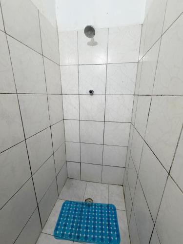 a shower with a blue mat in a bathroom at Quarto no centro 207 in Manaus