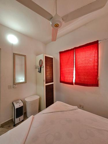 a bedroom with a bed and a red window at Caribbean Domicil Apartment 02 in Las Terrenas