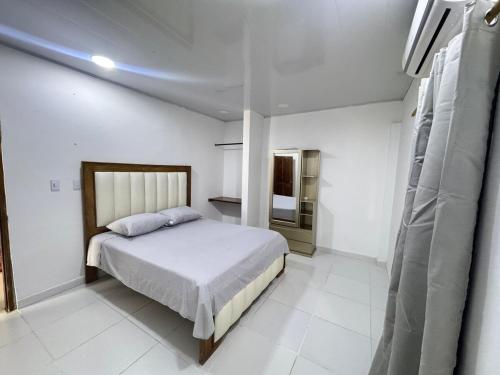 a bedroom with a bed in a white room at Casa Cabaña Elena - Coveñas in San Antero