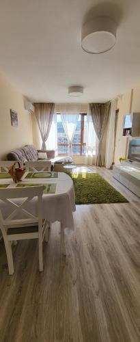 a white living room with a table and a couch at Apartament Silvi Super View in Varna City
