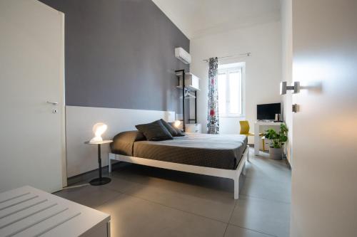 a bedroom with a bed in a white room at Suite Inn Catania in Catania