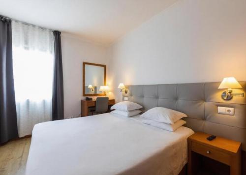 Llit o llits en una habitació de Hotel Arcanjo