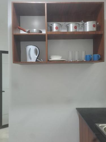 drewniana półka z garnkami i patelniami w kuchni w obiekcie Meg place w mieście Ofankor