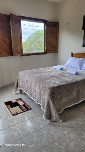 a bedroom with a large bed with a window at Pousada irmãos Calixto in Portalegre