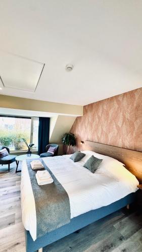una camera da letto con un grande letto e una grande finestra di Hotel José a Blankenberge