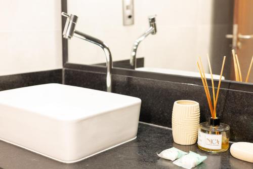 a bathroom with a white sink in a black counter at Pousada do Nica in Fernando de Noronha