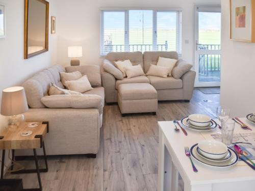 a living room with a couch and a table at Seaspace in Bacton