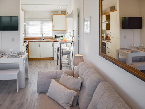a living room with a couch and a kitchen at Seaspace in Bacton