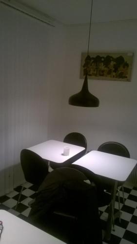 two tables and chairs in a room with a checkered floor at Pasescia Bed and Breakfast. in Kolind