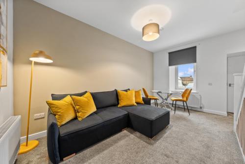a living room with a couch and a table at 1-Bed Duplex with Sofa Bed in Airdrie Lanarkshire - Long Stays - Free Parking in Airdrie