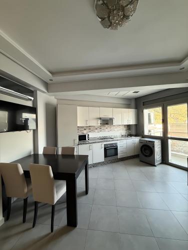 a kitchen with a dining room table and chairs at Appart Hotel Bloom in Al Hoceïma