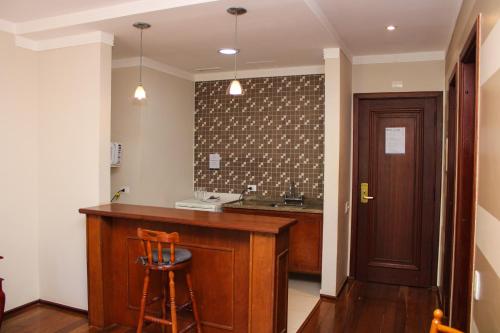 a kitchen with a counter and a bar with a sink at Hotel Home Green Home in Campos do Jordão