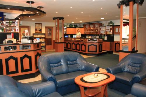 a store with two chairs and a table and a counter at Hotel Ózd in Ózd