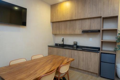 a kitchen with a wooden table with chairs and a sink at Hotel & hostal Morada in Puebla