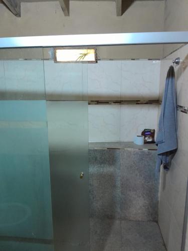 a glass shower door in a bathroom with a window at La Petite Maison Mariano Casa in Limpio
