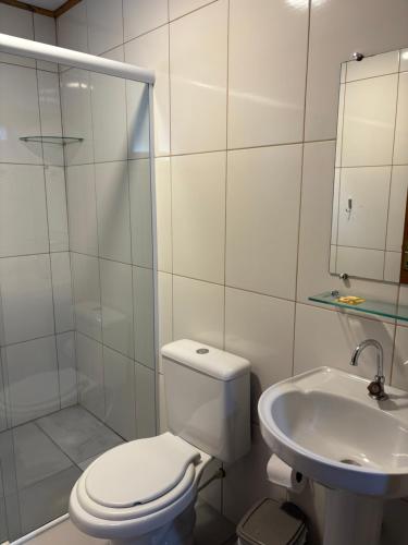 a white bathroom with a toilet and a sink at Pousada São Miguel Natureza e Descanso em Cunha SP in Cunha