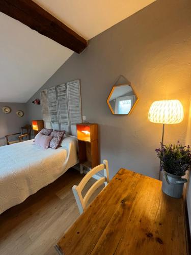 a bedroom with a bed and a wooden table at Chambres et Gîte Peyroutas "Amélie" à Vignonet St Emilion in Vignonet