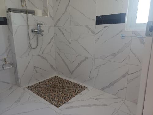 a bathroom with a shower with white marble tiles at Casa Alegiu in Las Galeras