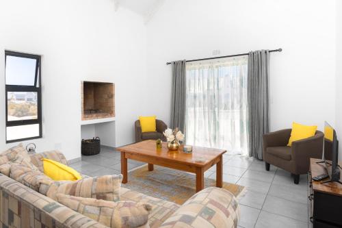 a living room with couches and a coffee table at The North Atlantic Sands Beach House in Velddrif