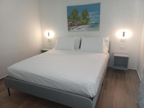 a white bed in a room with two lights at Casa Alegiu in Las Galeras