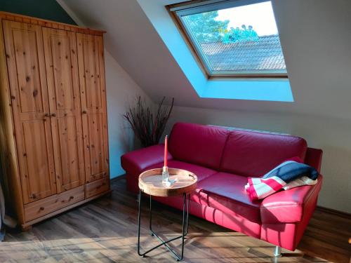 a living room with a red couch and a table at Lenzer Parkblick am Plauer See in Lenz