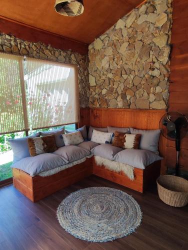 eine Couch in einem Raum mit einer Steinwand in der Unterkunft Alojamiento el Arrayán in Temuco