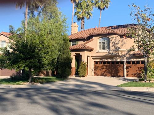 a house with palm trees in front of a driveway at Private bedroom and bathroom in Rancho Santa Margarita