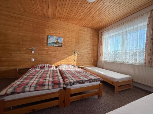 a bedroom with two beds and a window at Penzion Emílie in Jeseník