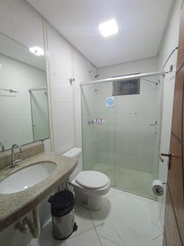 ein Badezimmer mit Dusche, Toilette und Waschbecken in der Unterkunft Hotel Milla in Teixeira de Freitas