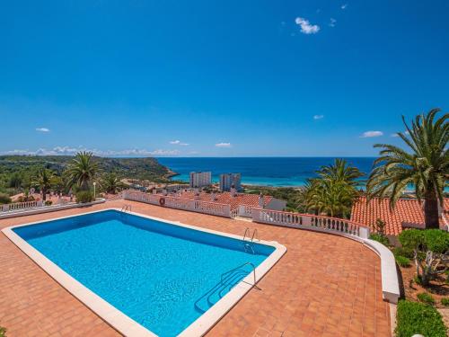a swimming pool on a brick patio with the ocean in the background at Alta Mar Apartment by 3VILLAS in Son Bou