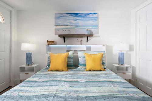 a bedroom with a bed with yellow pillows at Vitamin Sea Suites 2 in Carolina Beach