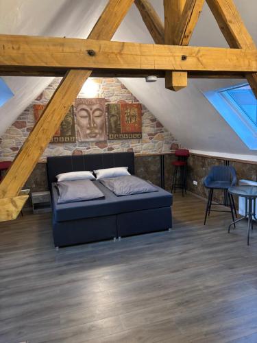 a bedroom with a bed and a stone wall at Haus am Freilinger See Bar in Blankenheim