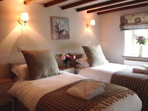 a bedroom with two beds with flowers on them at Winnow Barns Holidays in Ashbourne