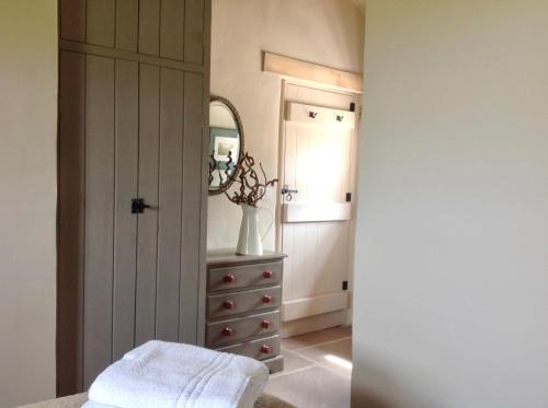 a dressing room with a mirror and a dresser at Winnow Barns Holidays in Ashbourne