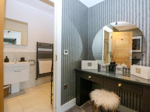 a bathroom with a vanity with a mirror and a sink at 2 Glan Yr Aber in Colwyn Bay