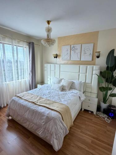 a bedroom with a large bed and a chandelier at Sweet Haven - Sports Rd in Westlands