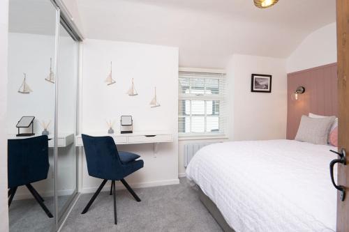 a bedroom with a bed and a desk and a chair at Tŷ Gwyn Bach, Conwy in Conwy