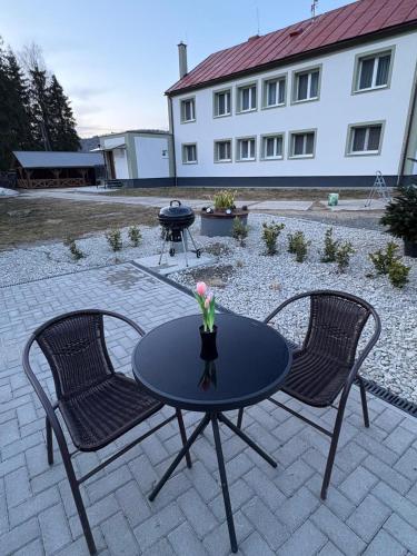 a table with two chairs and a bbq grill at Jedlinka in Palota