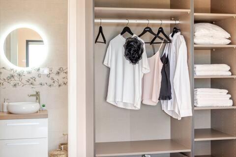 a bathroom with a closet with white shirts and towels at Sea View House with Jacuzzi - Casa Bianca Brač in Selca