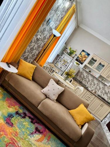 a living room with a brown couch and a colorful rug at Getaway Nook in Dedoplis Tskaro