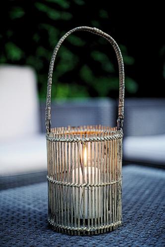 a candle in a wicker basket sitting on a table at Cocoon Spa in Issenheim