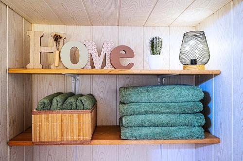 a shelf with towels and a sign that says hope at Cocoon Spa in Issenheim
